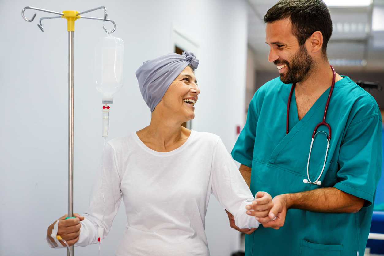 Paciente oncológica feliz andando ao lado do enfermeiro