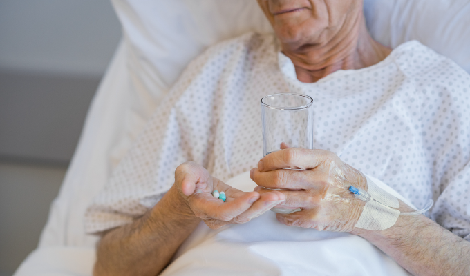 Top 5 notícias: paciente idoso sentado em uma maca e segurando medicamento nas mãos