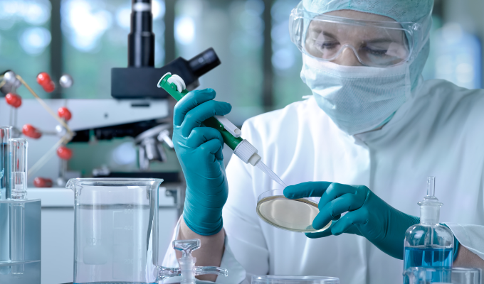 Top 5 notícias: um cientista vestido com um macacão branco contra risco biológico e manuseando produtos químicos em um laboratório