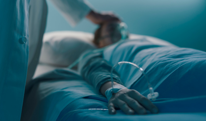 COVID-19: homem deitado em uma cama de hospital com um médico ao seu lado