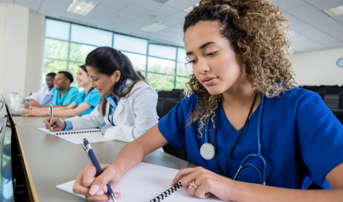 Enfermagem: enfermeiras acompanhando uma aula e fazendo anotações em cadernos