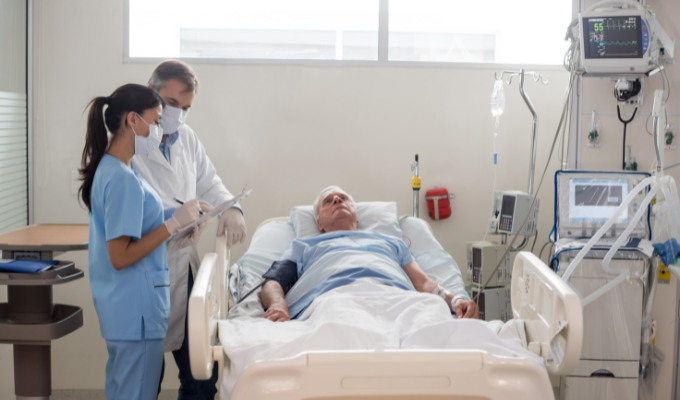 Farmácia clínica na UTI: farmacêutica junto ao médico no atendimento a um paciente deitado em leito de UTI